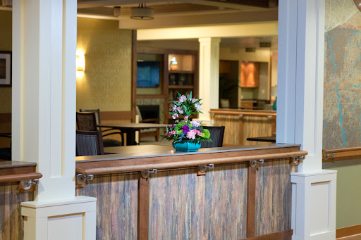 A welcoming lobby space featuring a decorative flower arrangement, comfortable seating, and warm lighting.