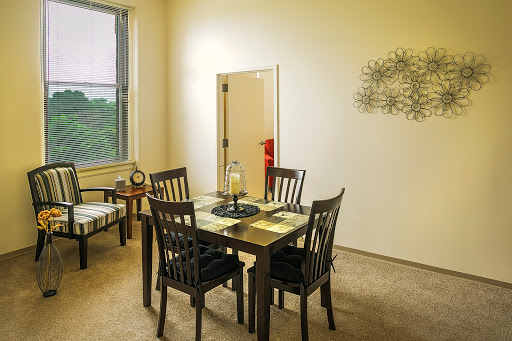 A cozy dining area featuring a wooden table and chairs, complemented by simple decor and natural light from the window.