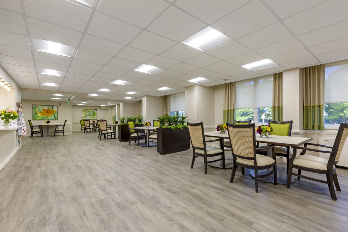 A modern dining area with neatly arranged tables and chairs, featuring contemporary decor and ample lighting.