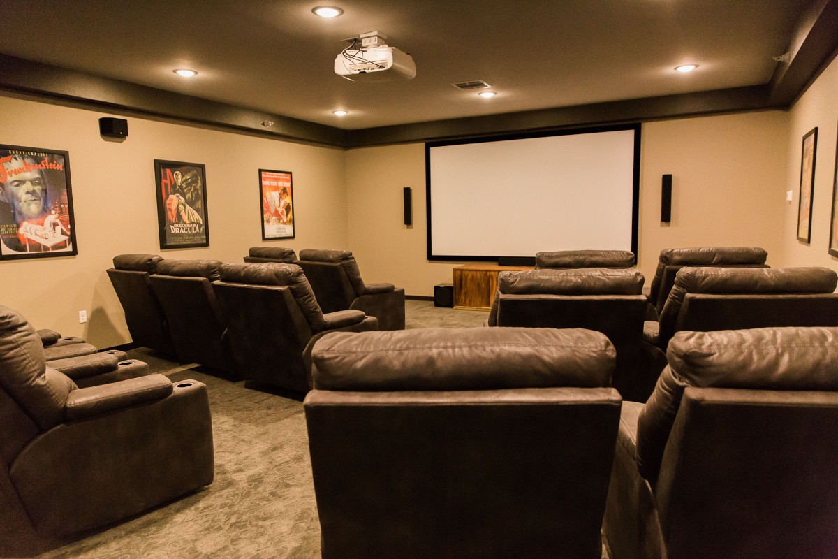 A cozy home theater setup with comfortable recliners and a large projector screen.