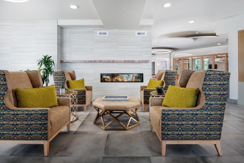 A modern living room with a central fireplace, surrounded by comfortable seating and stylish decor.