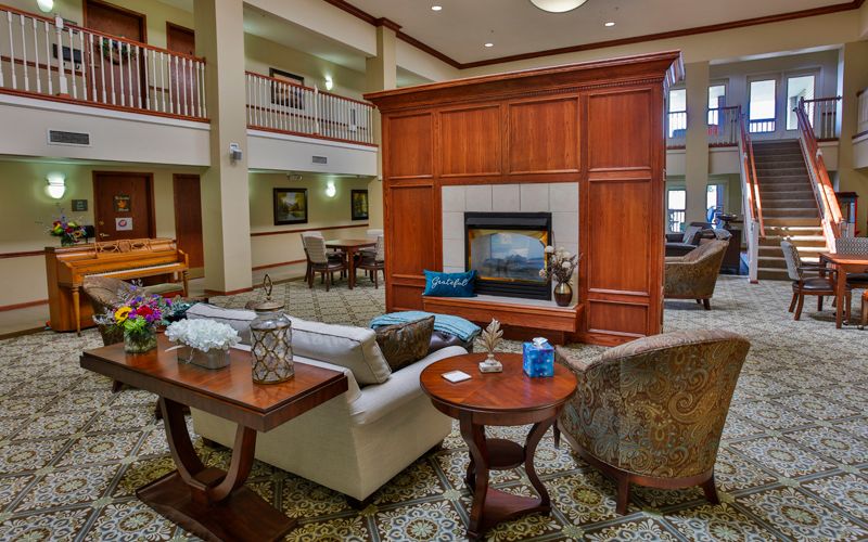 A luxurious lobby area featuring a central fireplace, elegant seating, and tasteful decor.