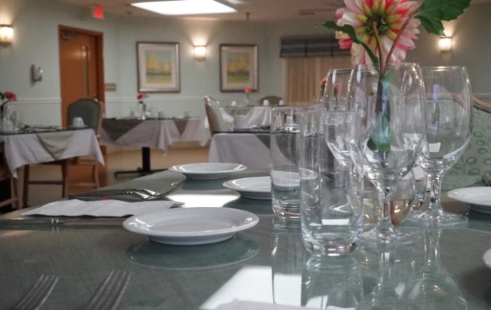 An elegantly set dining table in a restaurant, featuring neatly arranged plates and glasses.