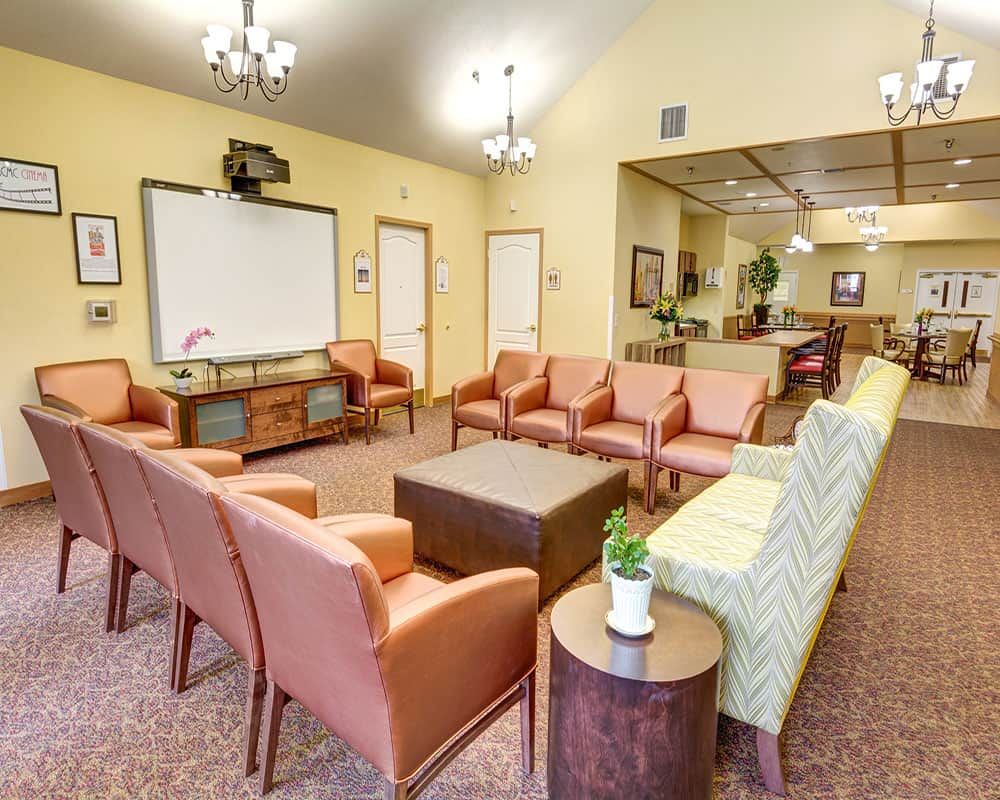 A spacious and well-lit waiting room featuring comfortable seating and a television.
