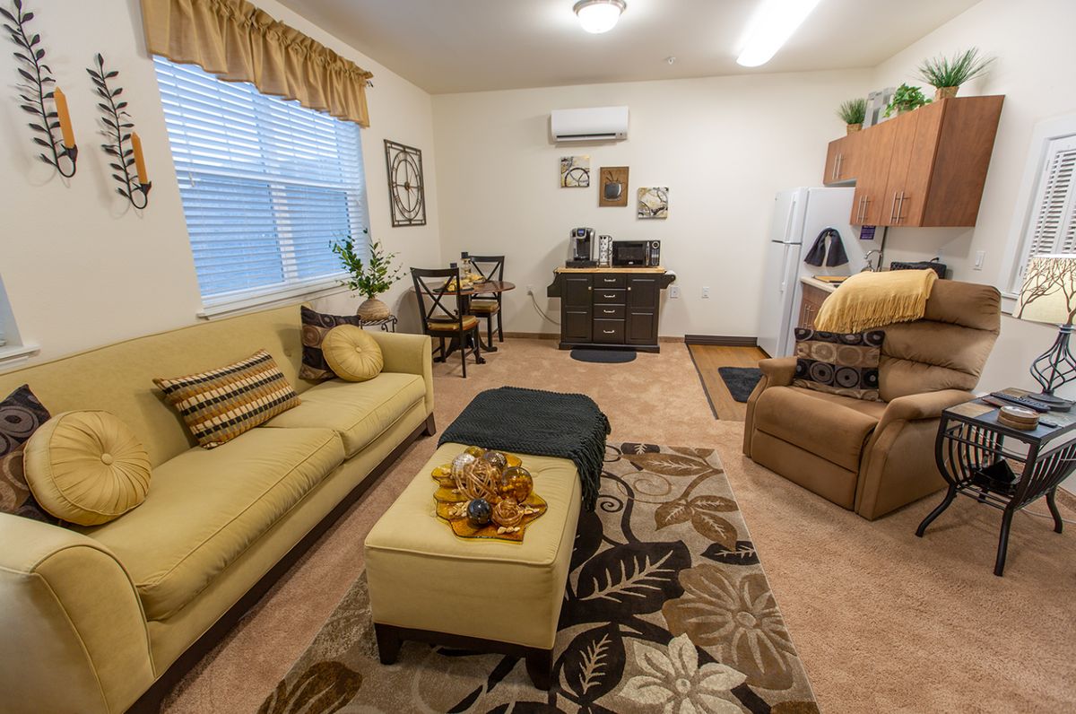 A cozy living room featuring a sofa, decorative carpet, and assorted furniture.