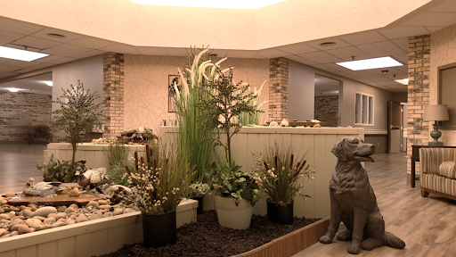 A serene indoor garden featuring decorative plants and a calming fountain, enhancing the modern interior space.