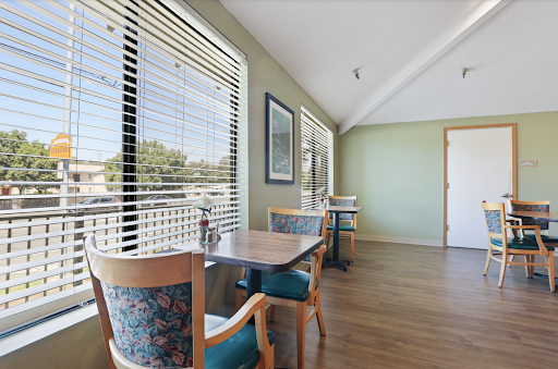 A cozy dining area with natural light filtering through the window blinds.