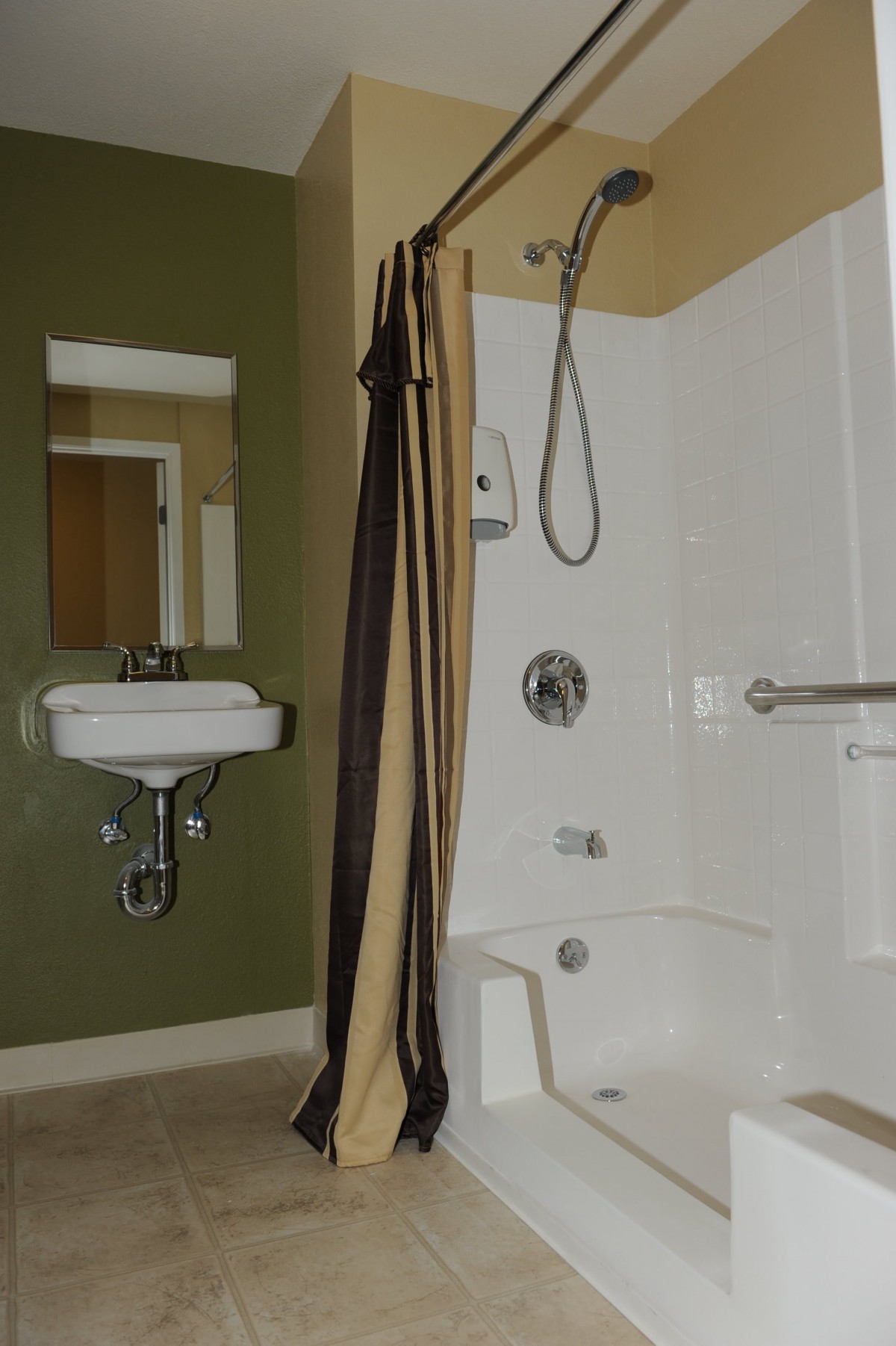 A bathroom with a shower area, sink, and mirror.