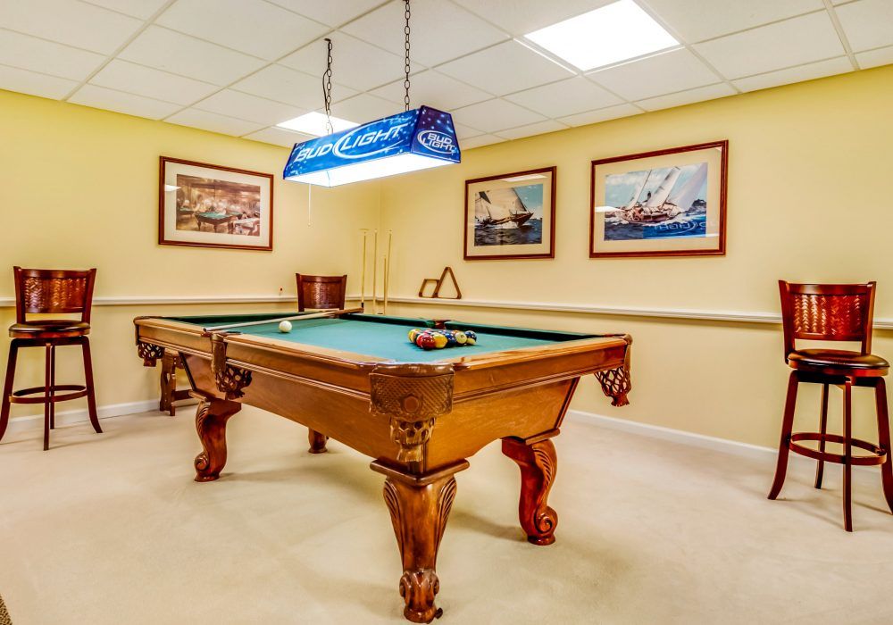 A billiard room featuring a pool table, wall artwork, and overhead lighting.