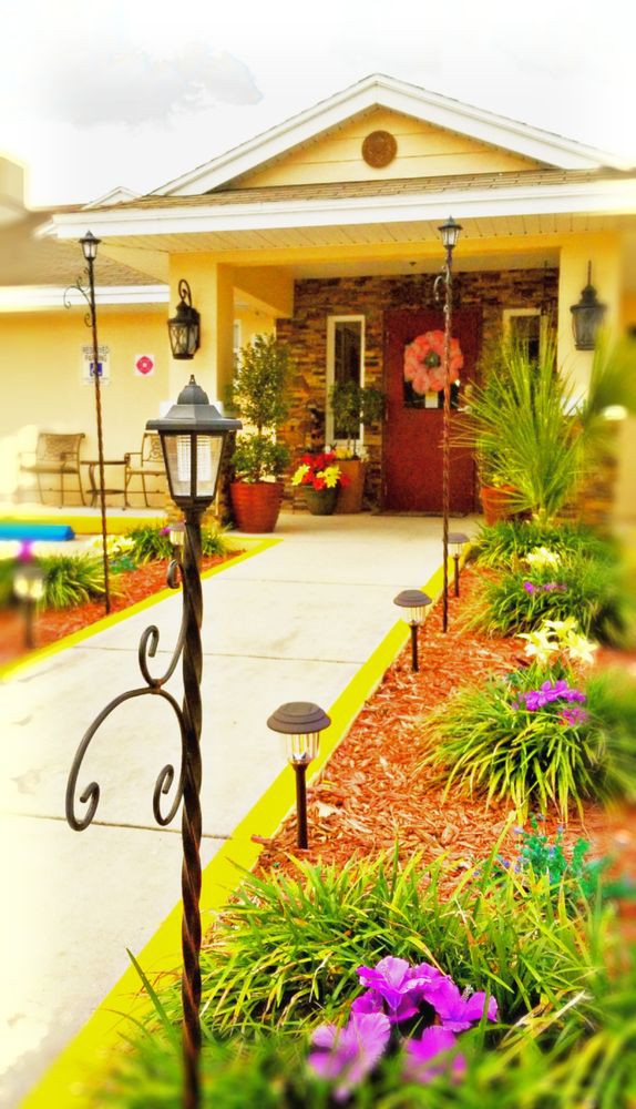 A colorful and inviting front porch with lush landscaping and decorative lighting.