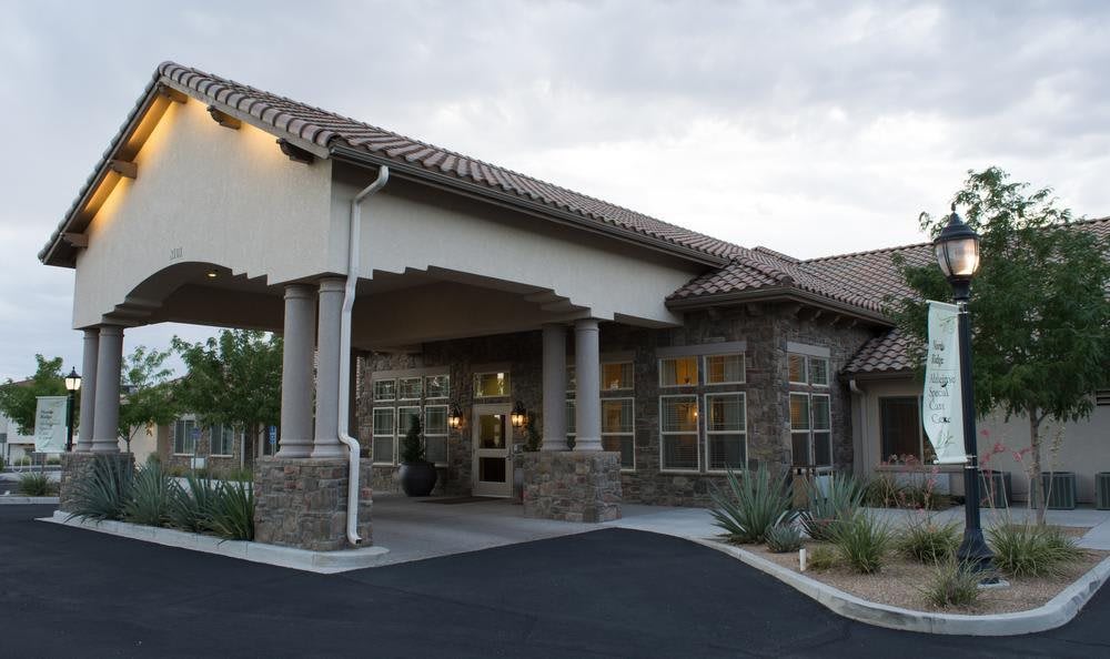 A modern building with a covered entrance and stone facade.