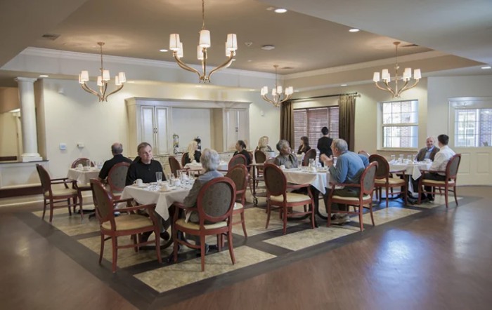Seniors enjoying a meal together in an elegantly decorated dining room.