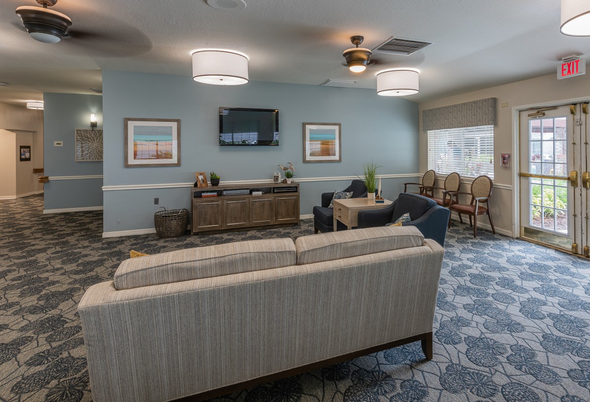 A cozy living room with comfortable seating, modern lighting fixtures, and a wall-mounted television.
