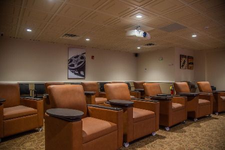 A luxurious home theater with comfortable seating and a ceiling-mounted projector.