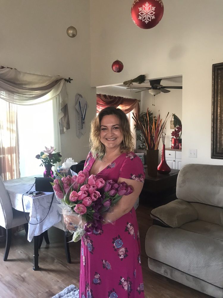 A woman holding a bouquet of flowers in a living room.