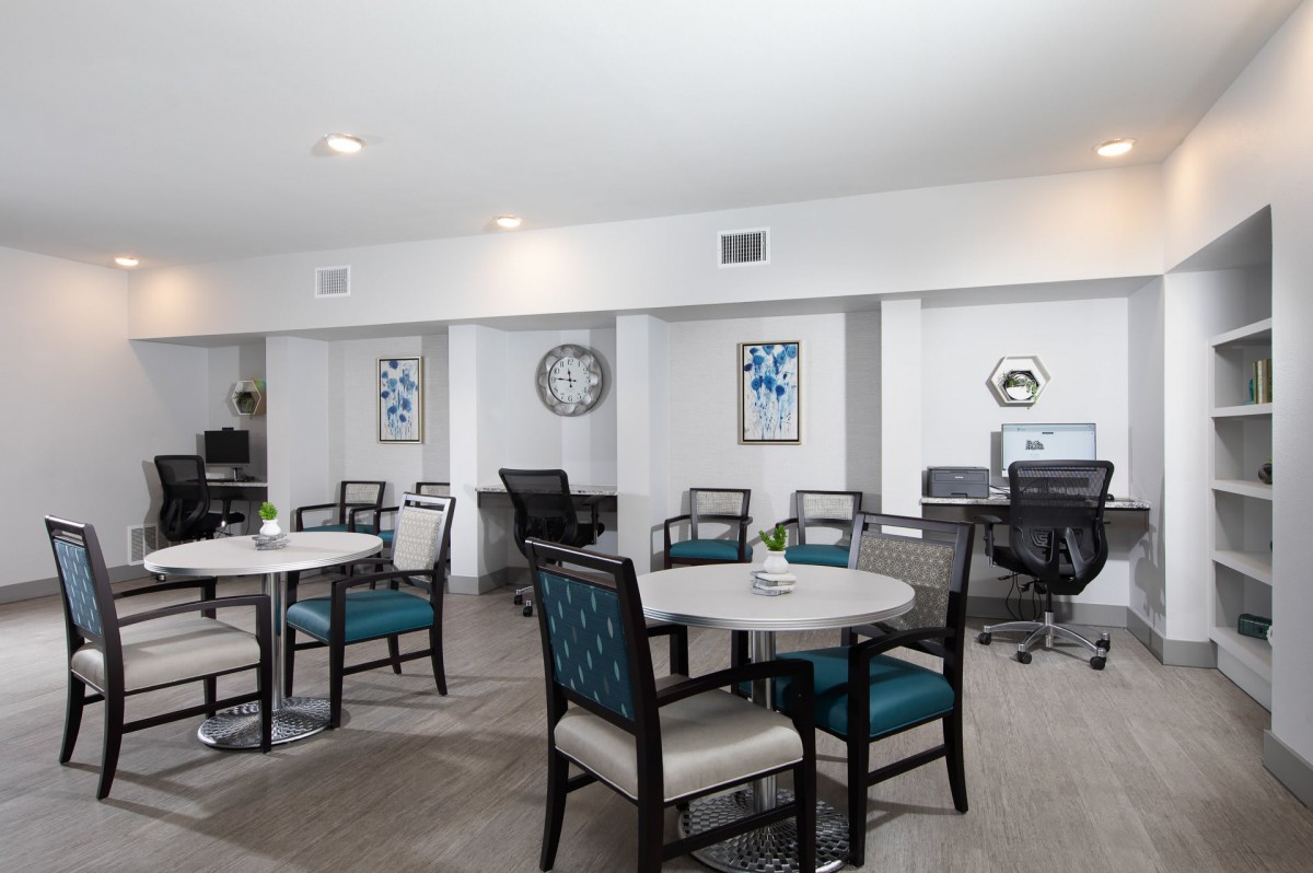 A well-organized office space with tables, chairs, and computers for collaborative work.