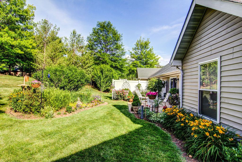 A well-maintained backyard garden with a patio and lush greenery.