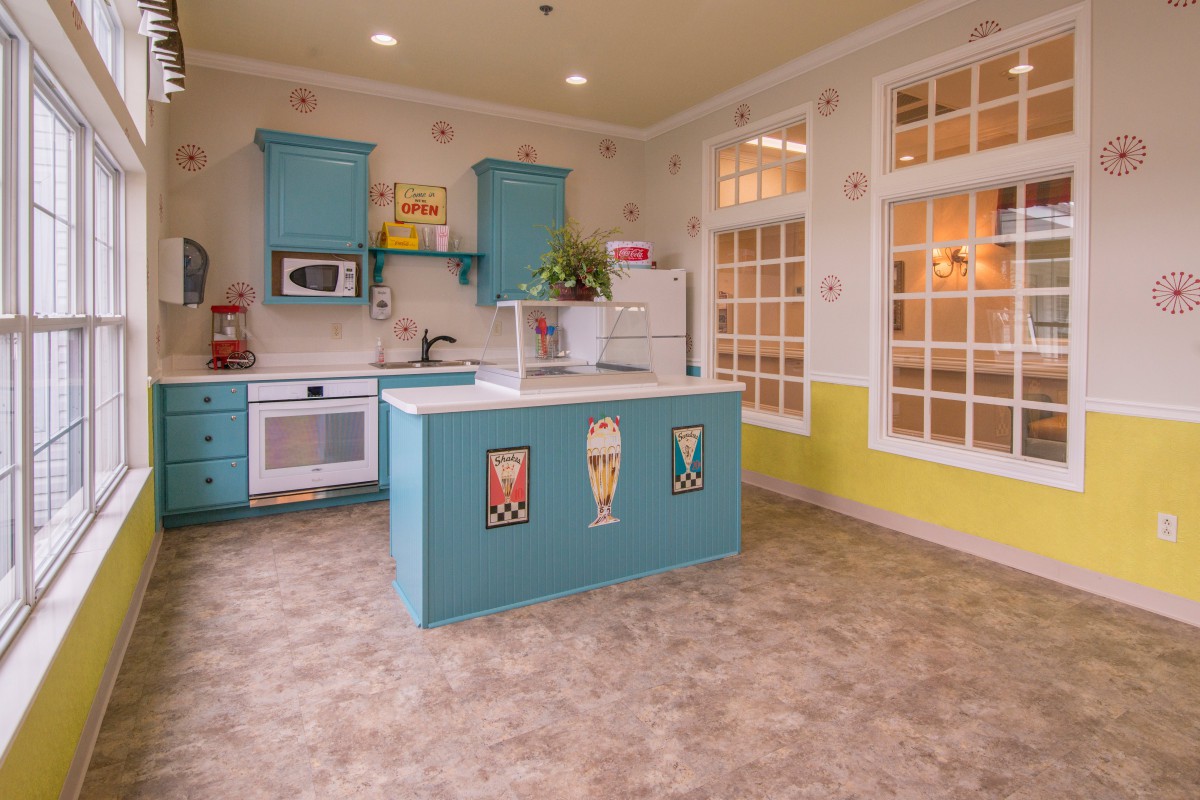 A vibrant retro-style kitchen with colorful cabinetry and a cozy atmosphere.