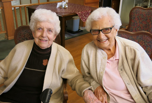 Two elderly women sharing a joyful moment together, showcasing the beauty of friendship.