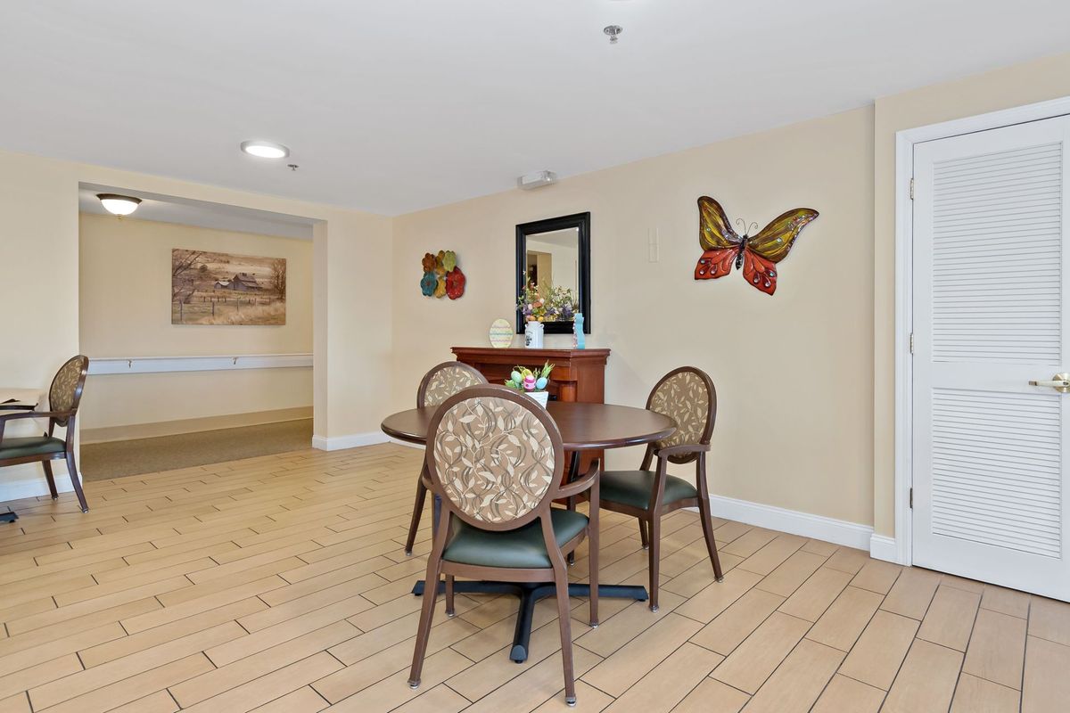 A cozy indoor dining area with a round table, four chairs, and decorative wall art.