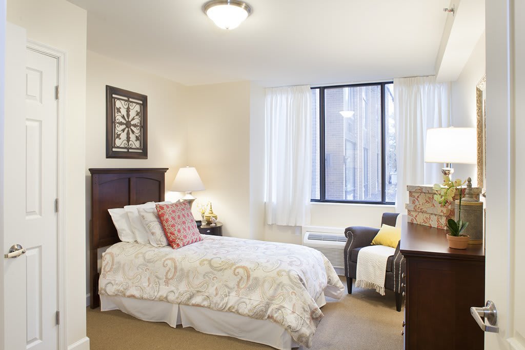 A cozy bedroom with a single bed, window, and stylish decor.