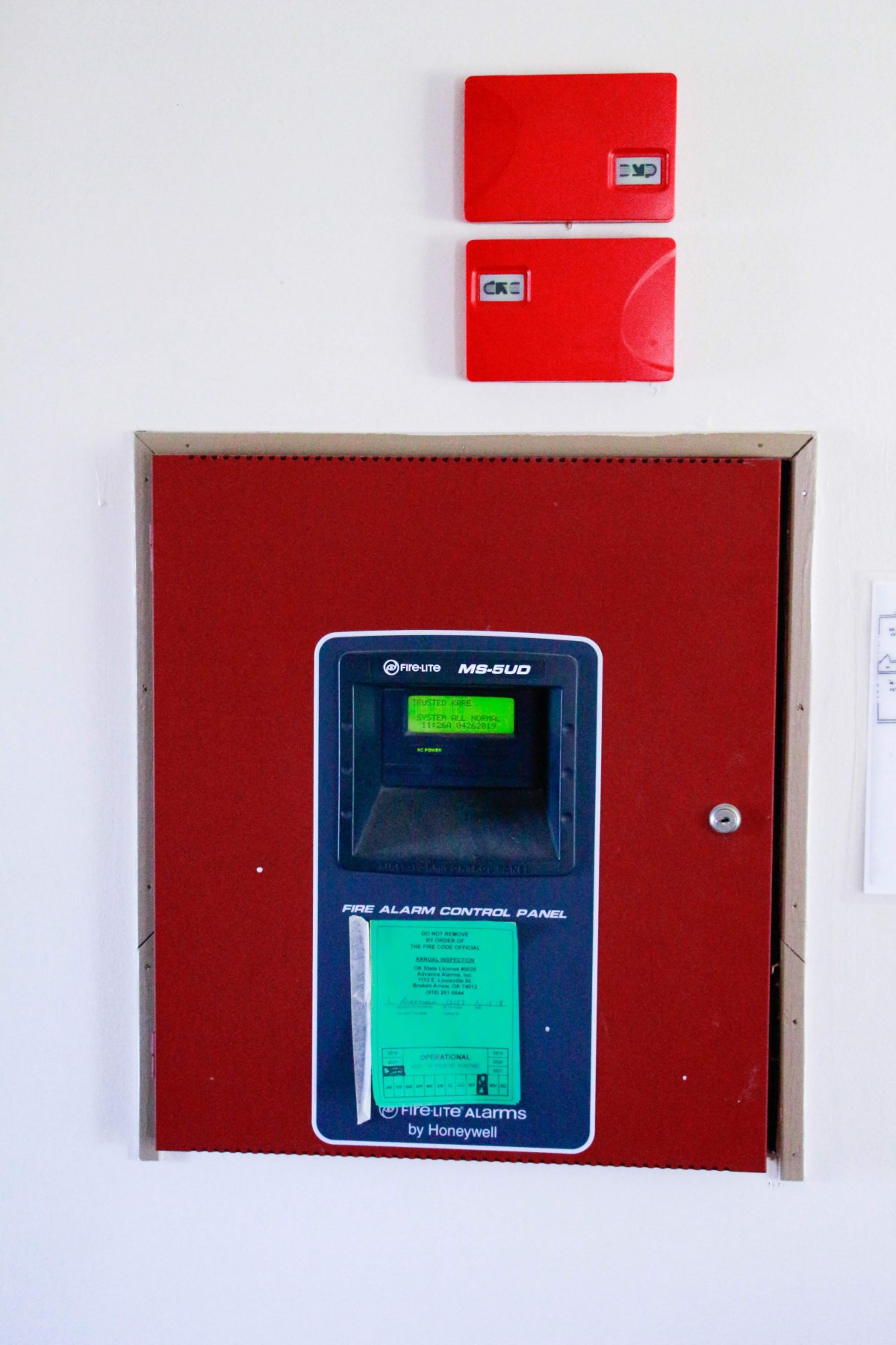 A parking ticket machine installed indoors with a red box above it.
