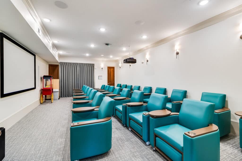 A modern home theater room with comfortable seating and a projector.
