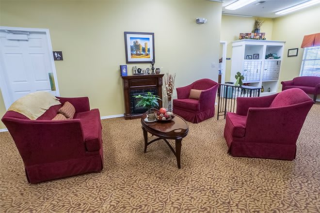 A cozy living room with red armchairs and a wooden coffee table.