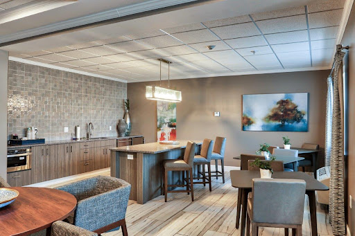 A modern lounge area featuring a kitchenette and dining space, designed for comfort and social interaction.