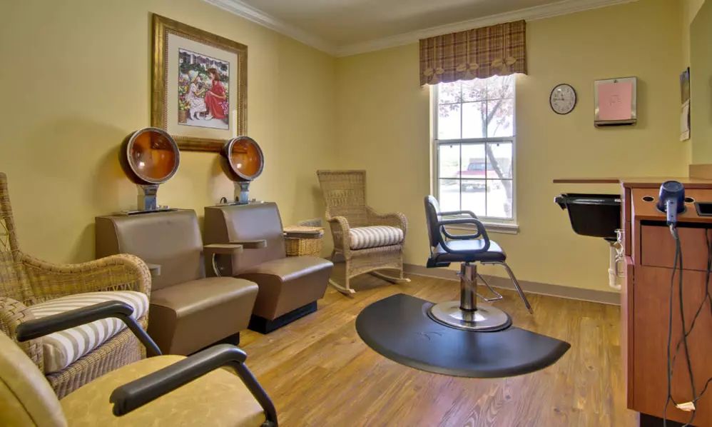 A cozy hair salon interior with seating and hair styling equipment.