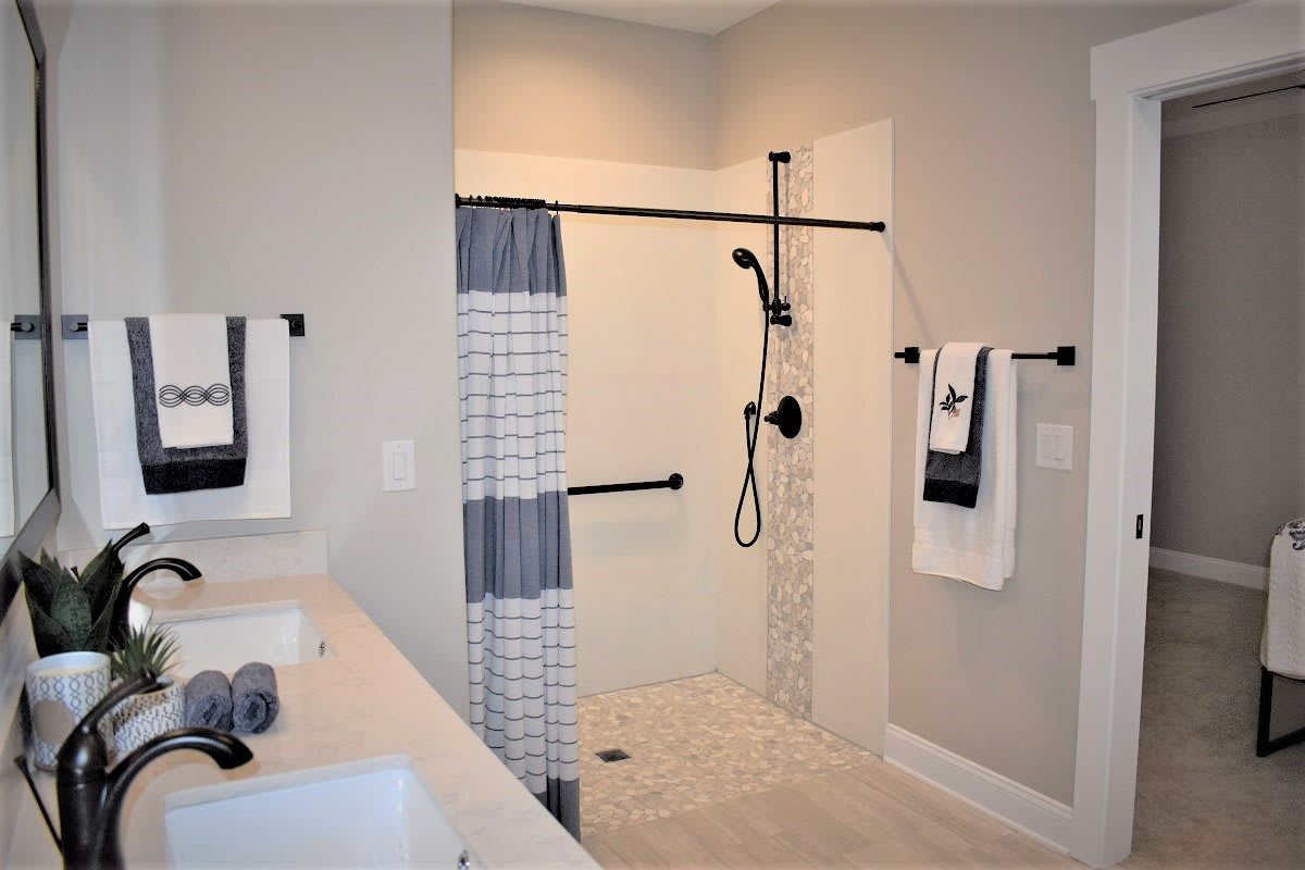 A modern bathroom featuring a walk-in shower and gray color scheme.