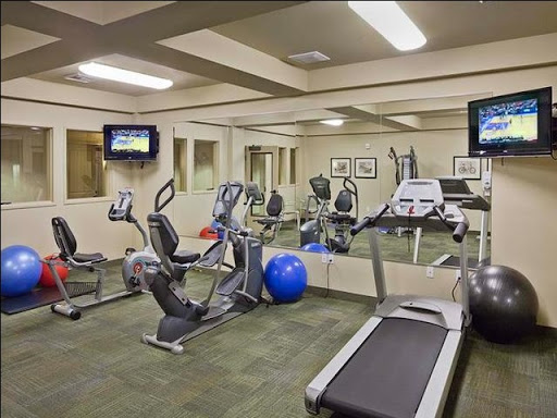 A well-equipped indoor gym featuring various exercise machines and a workout area.