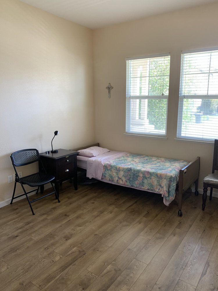A minimalist bedroom with a single bed and wooden flooring.