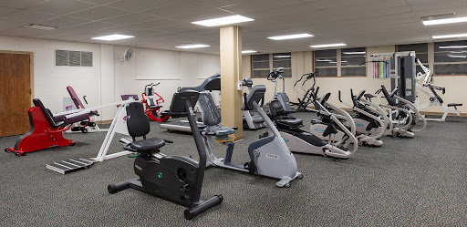 A view of a well-equipped gym featuring various cardio machines.