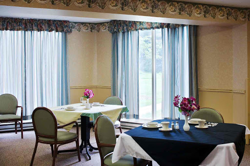 A cozy dining area featuring neatly set tables and natural light streaming through the windows.
