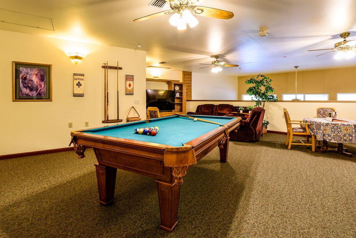 A cozy game room featuring a pool table and comfortable seating.