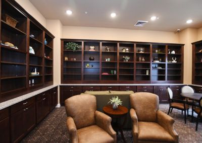 A cozy library room with bookshelves and comfortable chairs.
