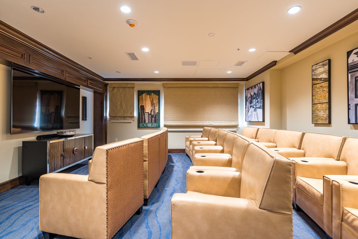 A luxurious home theater room featuring comfortable seating and elegant decor.