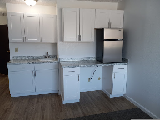 A modern kitchen featuring white cabinets and stainless steel appliances.
