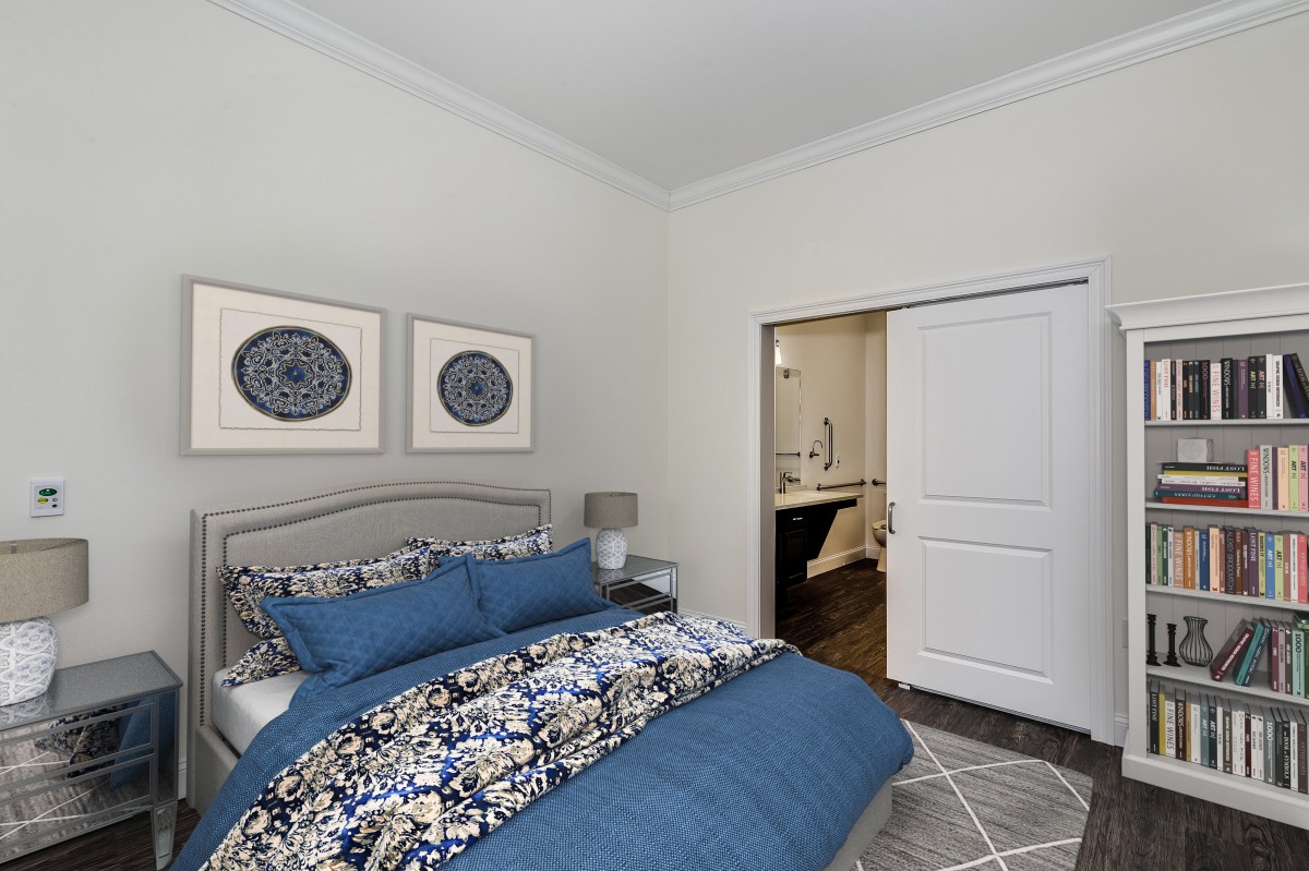 A cozy bedroom with blue bedding, decorative artwork, and a closet.