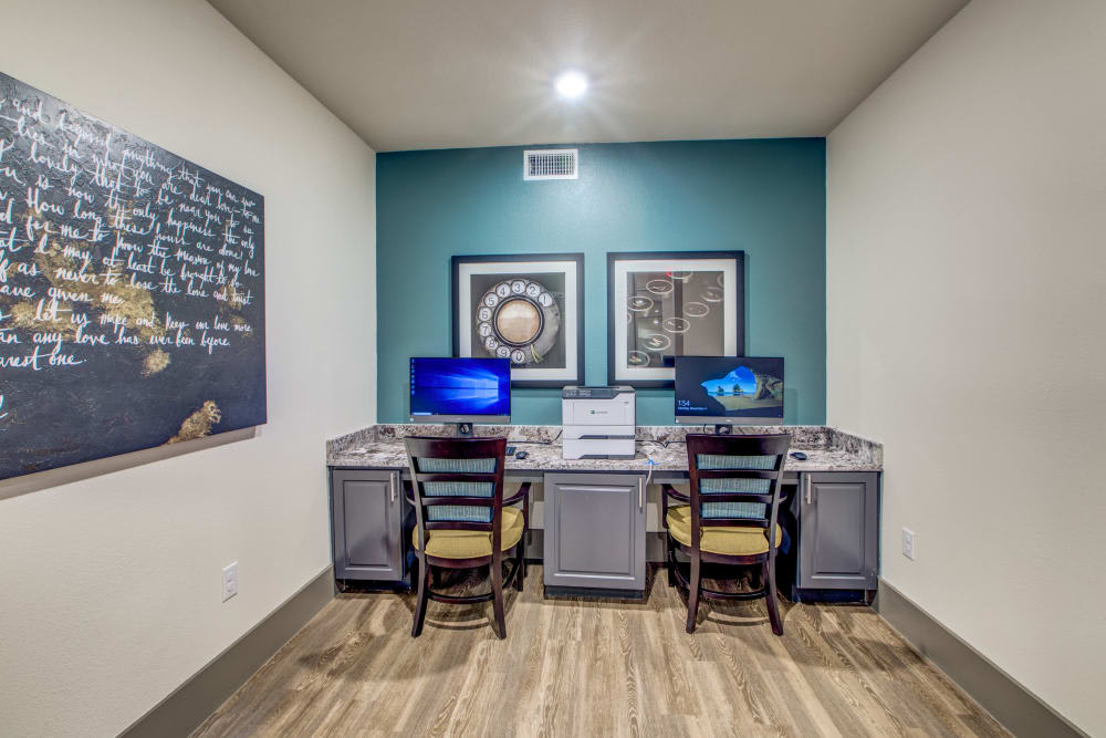 A small office workspace equipped with two computers and chairs, featuring minimalist interior design.