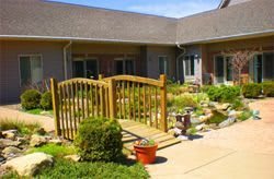 A beautifully landscaped courtyard with a wooden gate and lush greenery.