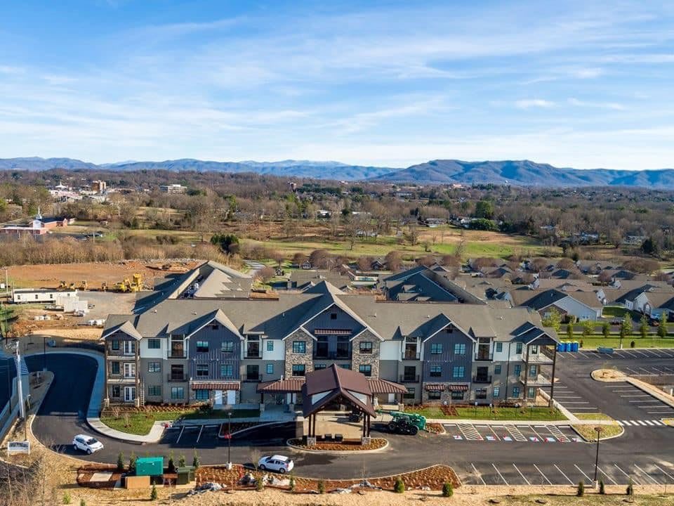 Aerial view of a suburban residential complex with mountains in the background.