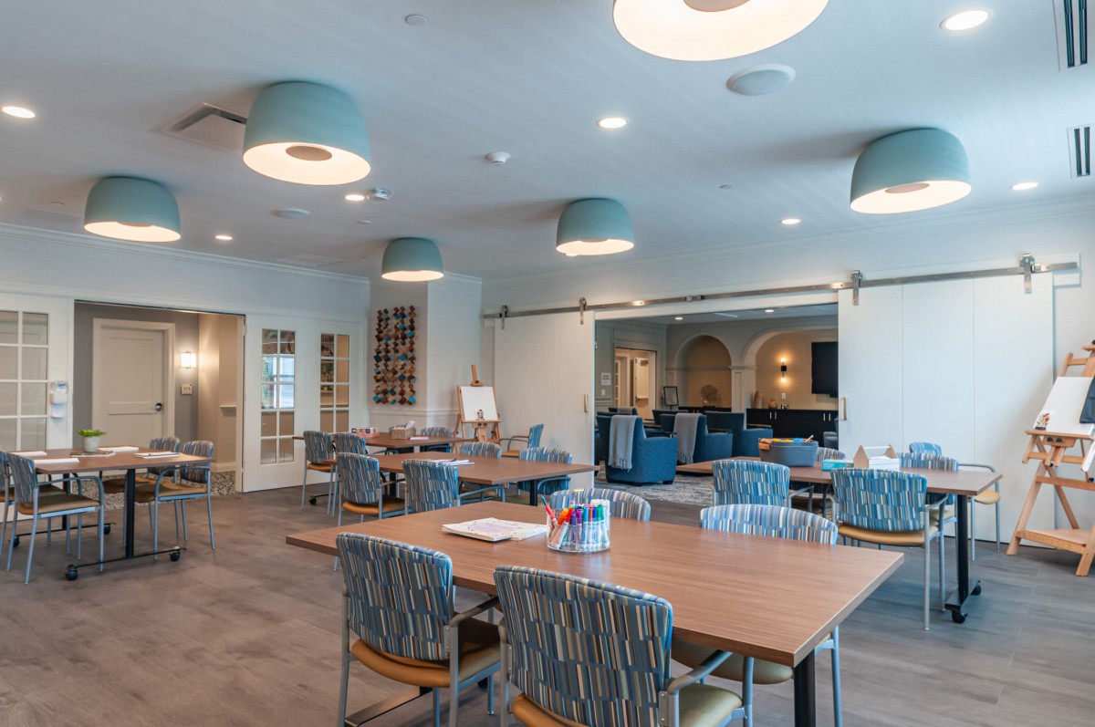 Modern workspace with tables and chairs, featuring stylish lighting.
