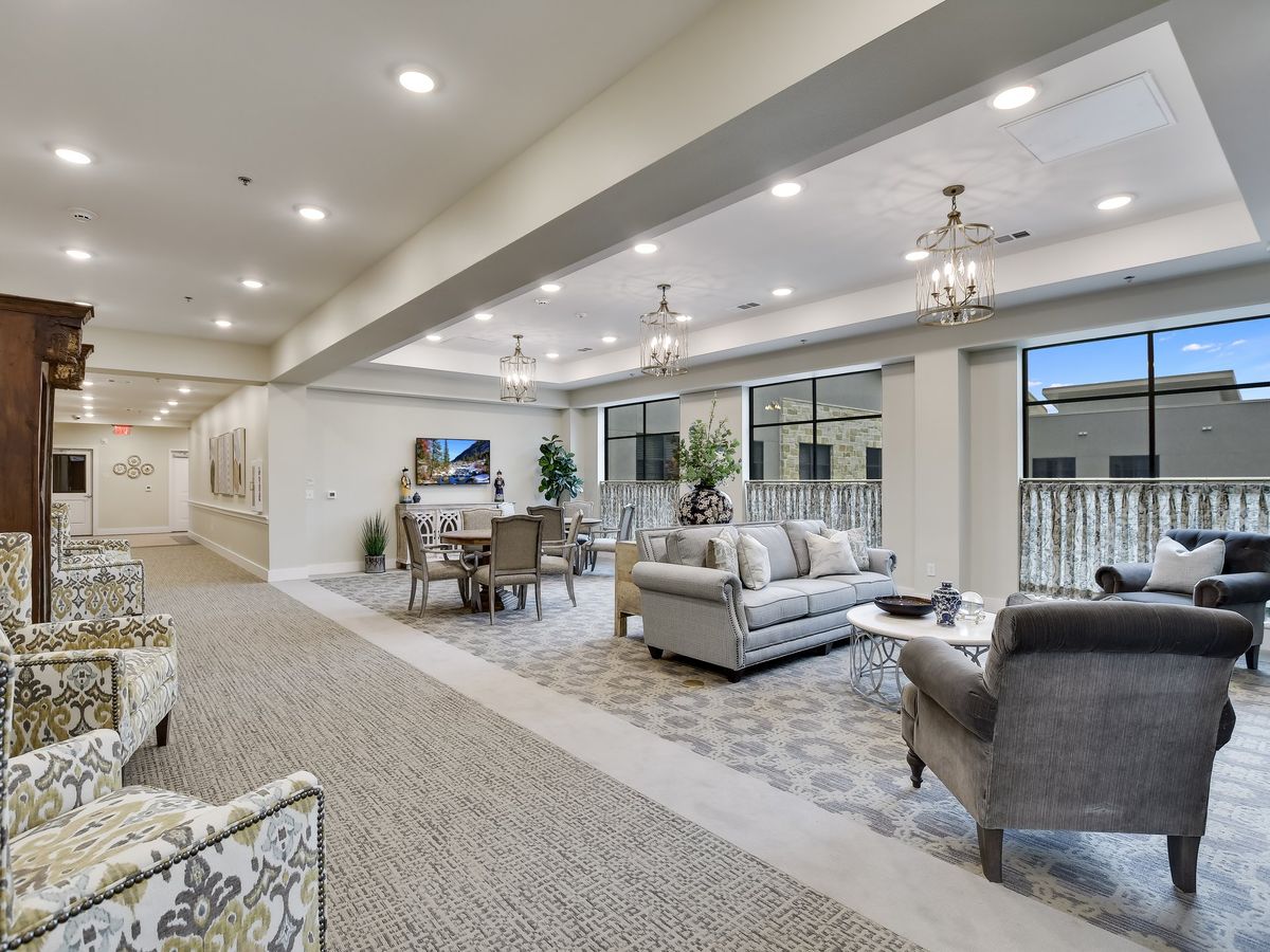 A spacious and elegantly designed living room with modern furniture and large windows.