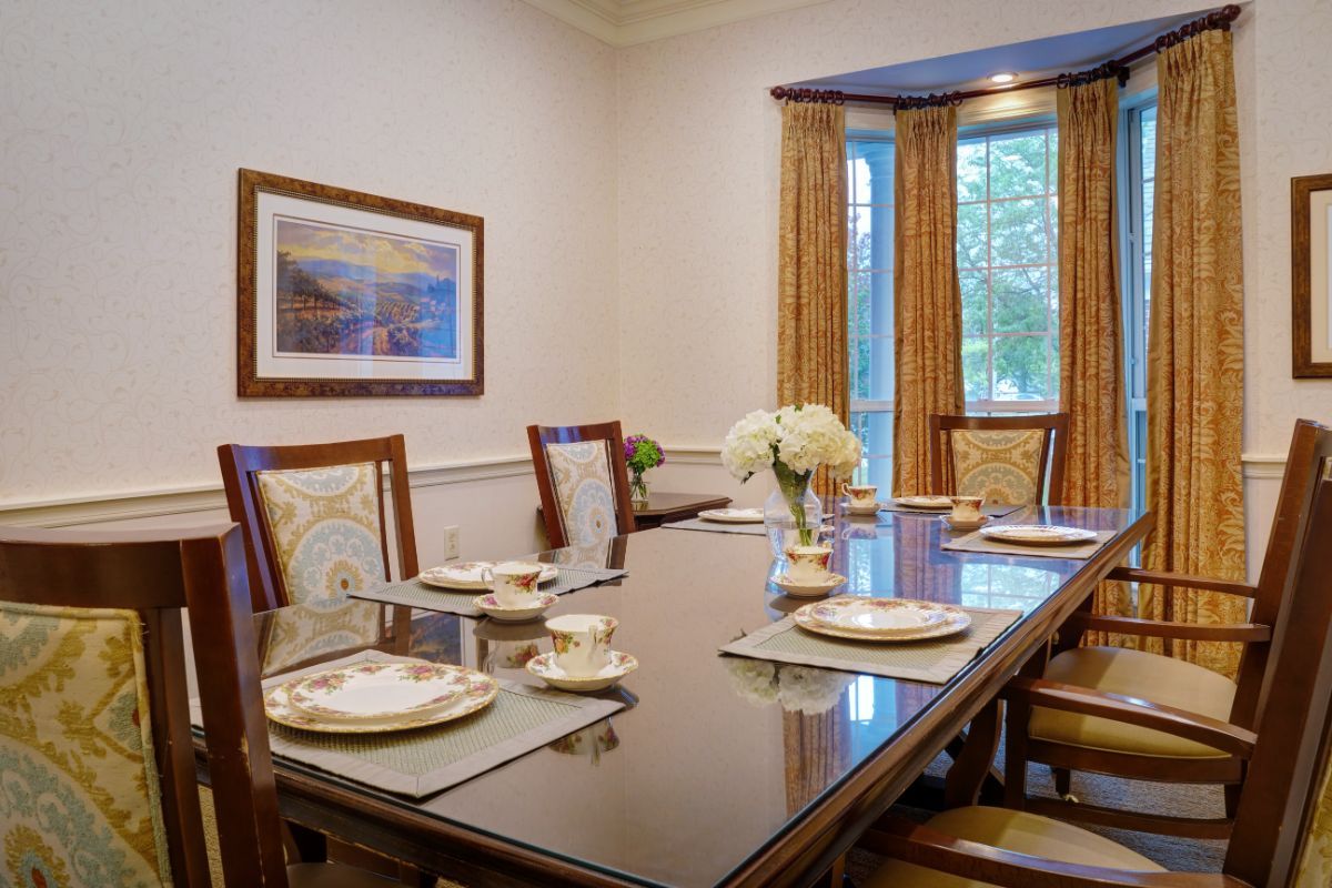 A neatly set dining room with a polished table and elegant decor.