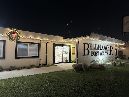 A brightly lit storefront of Belleflower Post Acute, showcasing its welcoming entrance at night.