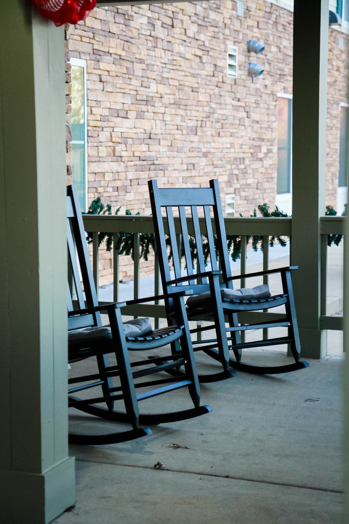 A cozy porch with two blue rocking chairs, perfect for relaxation.