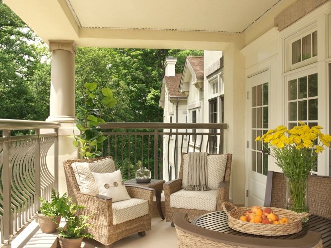 A cozy patio with wicker furniture and lush greenery.