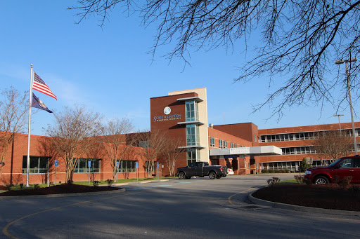 A modern brick building set against a clear blue sky.